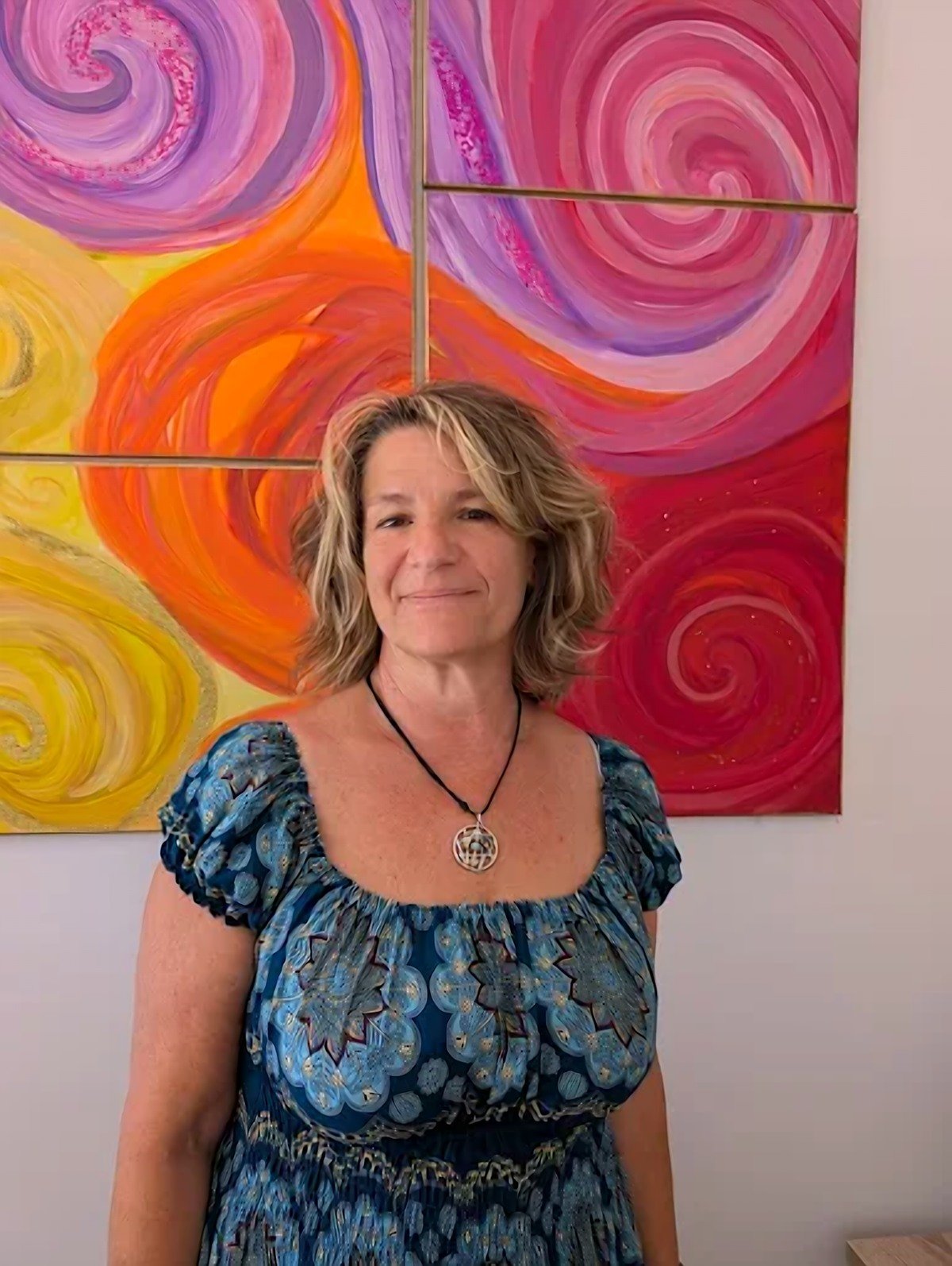 Nadine, kinésiologue, dans son cabinet de Fayence devant ses toiles peintes